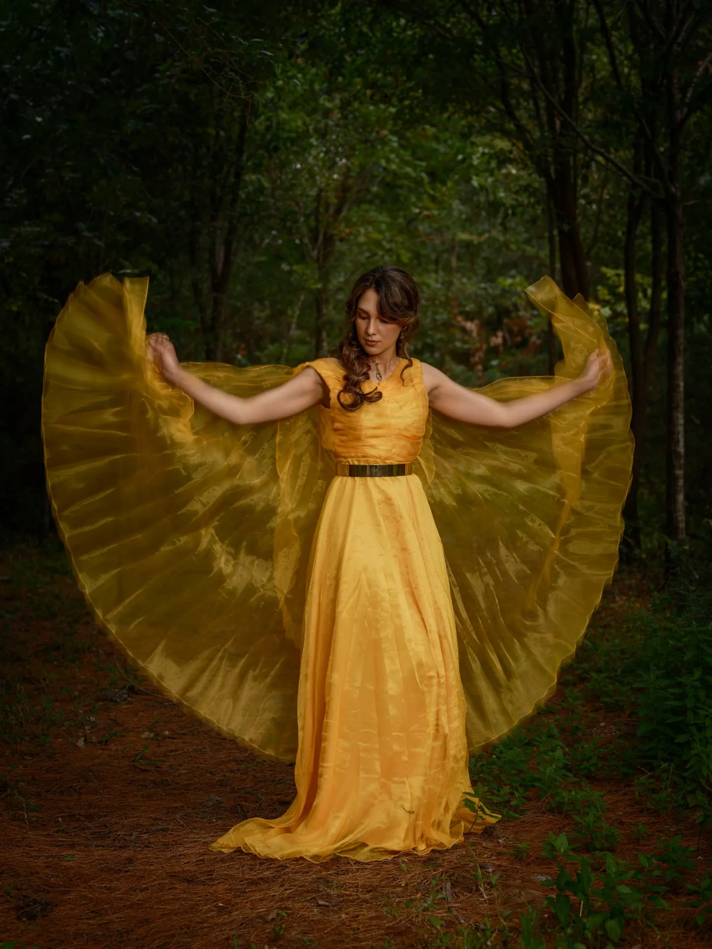 Celeste Lomelí con vestido amarillo rodeada de plantas verdes
